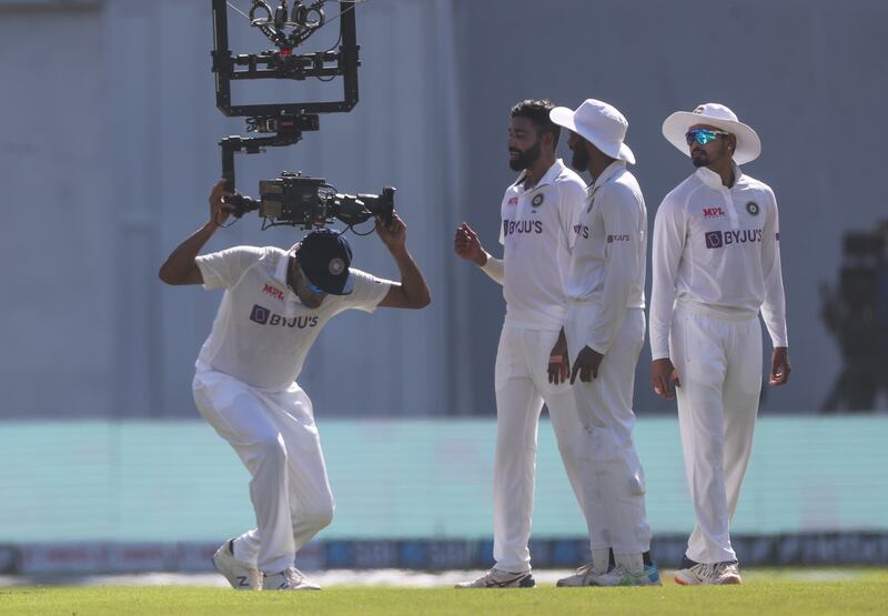 India's Ravichandaran Ashwin, left, grabs a hold of Spidercam. AP