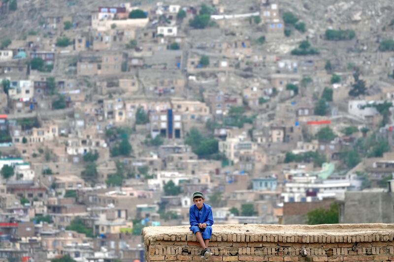 A boy looks out over Kabul, the capital of Afghanistan, from the roof of his house. AP
