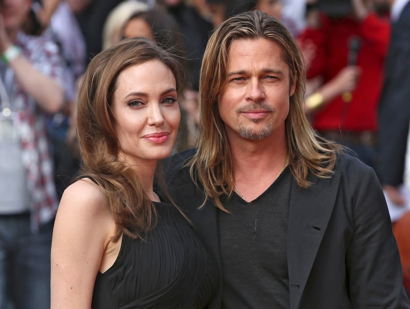 Angelina Jolie poses with her husband Brad Pitt as they arrive for the world premiere of his film World War Z in London June 2, 2013.  REUTERS/Neil Hall (BRITAIN  - Tags: ENTERTAINMENT TPX IMAGES OF THE DAY)   *** Local Caption ***  CLH100_BRITAIN_0602_11.JPG
