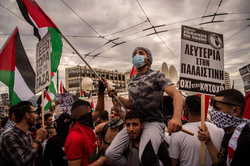 Pro-palestinians supporters wave flags and hold placards as they take part in a demonstration in solidarity with the Palestinians called over the ongoing conflict with Israel, outside the Israeli embassy, in Athens. AFP