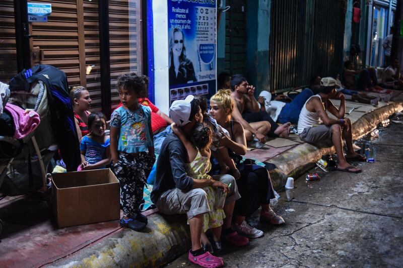 A Honduran migrant family taking part in a caravan heading to the US, rest on their arrival to Huixtla, Chiapas state, Mexico, on October 22, 2018. President Donald Trump on Monday called the migrant caravan heading toward the US-Mexico border a national emergency, saying he has alerted the US border patrol and military. / AFP / Johan ORDONEZ 
