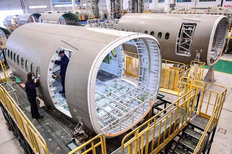 (FILES) This file photo taken on May 25, 2020 shows Chinese employees working on the fuselage of Airbus A220 aircraft at a factory in Shenyang in China's northeastern Liaoning province. Airbus announced on July 30, 2020 losses of 1.9 billion euros (2.2 billion USD) in the first six months a two-fold drop in aircraft delivery as a result of the impact of the coronavirus pandemic. - China OUT
 / AFP / STR
