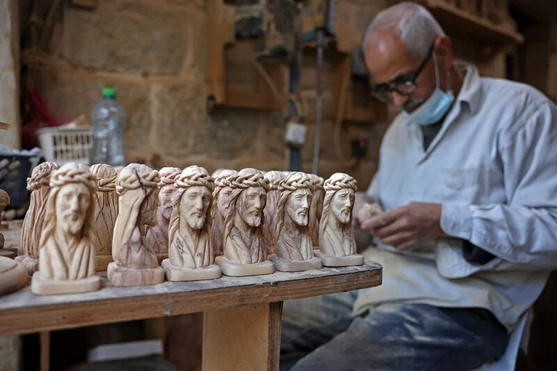 A Palestinian artisan makes statues from olive wood for Christmas. AFP