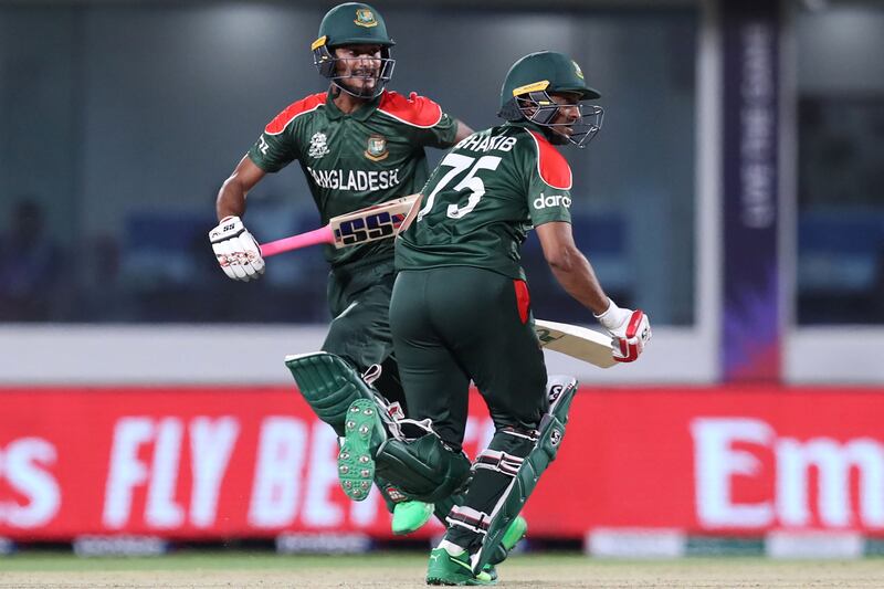 Bangladesh's Shakib Al Hasan (R) and teammate Mohammad Naim run between the wickets during the ICC men's Twenty20 World Cup cricket match between Oman and Bangladesh at the Oman Cricket Academy Ground in Muscat on October 19, 2021.  (Photo by Haitham AL-SHUKAIRI  /  AFP)