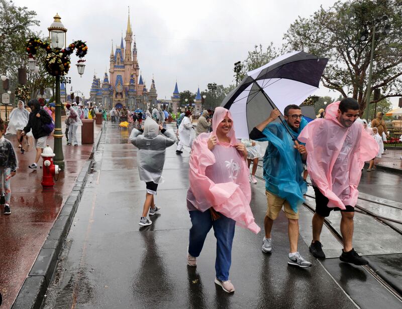 Guests brave the weather in the Magic Kingdom at Walt Disney World in Lake Buena Vista, Florida. AP