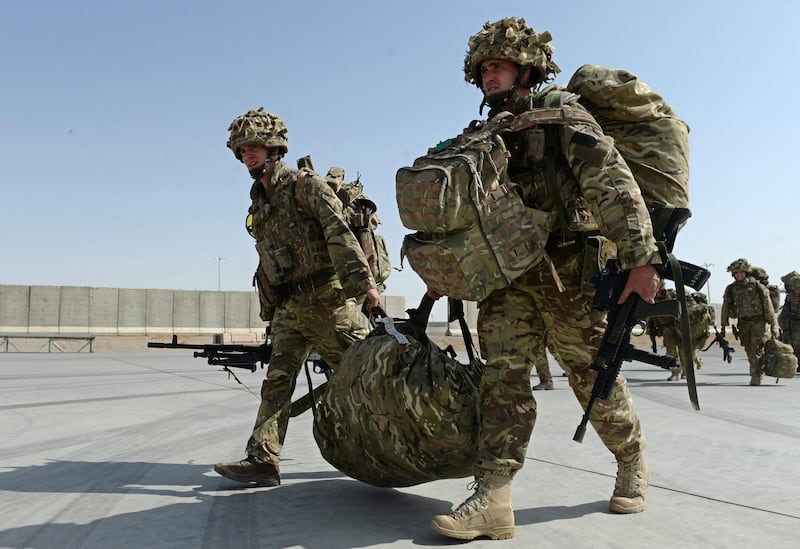 British soldiers walk with their gear after arriving in Kandahar on October 27, 2014, as British and US forces withdraw from the Camp Bastion-Leatherneck complex in Helmand province. British forces October 26 handed over formal control of their last base in Afghanistan to Afghan forces, ending combat operations in the country after 13 years which cost hundreds of lives. The Union Jack was lowered at Camp Bastion in the southern province of Helmand, while the Stars and Stripes came down at the adjacent Camp Leatherneck -- the last US Marine base in the country. AFP PHOTO/WAKIL KOHSAR (Photo by WAKIL KOHSAR / AFP)