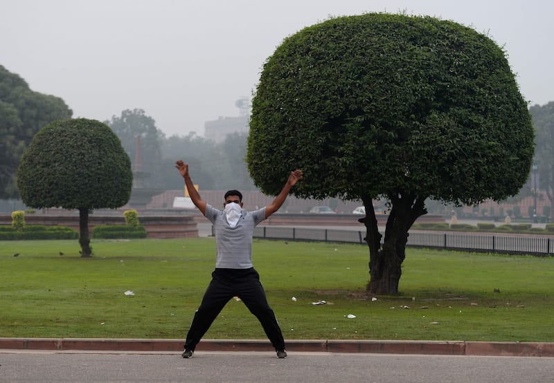 An Indian exercises early in the morning as smogs covers Rajpath ceremonial boulevard in New Delhi, on November 6, 2017.
Delhi, one of the world's most polluted cities, suffers from high levels of pollution during winter months, with millions of vehicles contributing to the city's bad air.  / AFP PHOTO / SAJJAD HUSSAIN