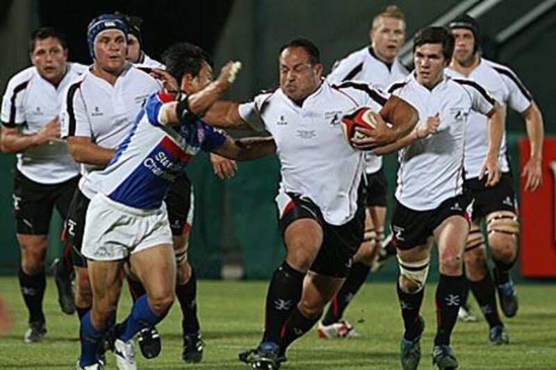 The Gulf's Michael Riley, centre, fends off a tackle by a Korean player.