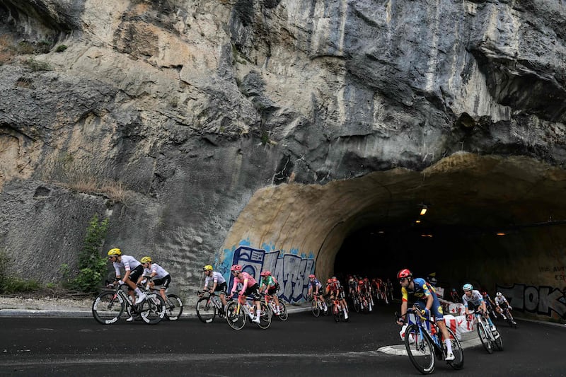 The peloton cycles through a mountain tunnel on Stage 5. AFP