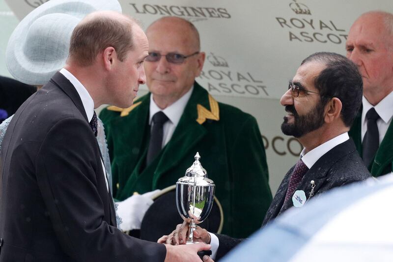 Prince William, Duke of Cambridge, presents a trophy to Sheikh Mohammed bin Rashid, Prime Minister and Ruler of Dubai, after Blue Point won the King's Stand Stakes on Day 1 of Royal Ascot. AFP