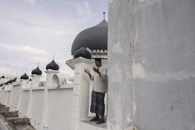 Sulaiman Amin prays at the mosque that was the only structure left standing in his village after the water receded. 