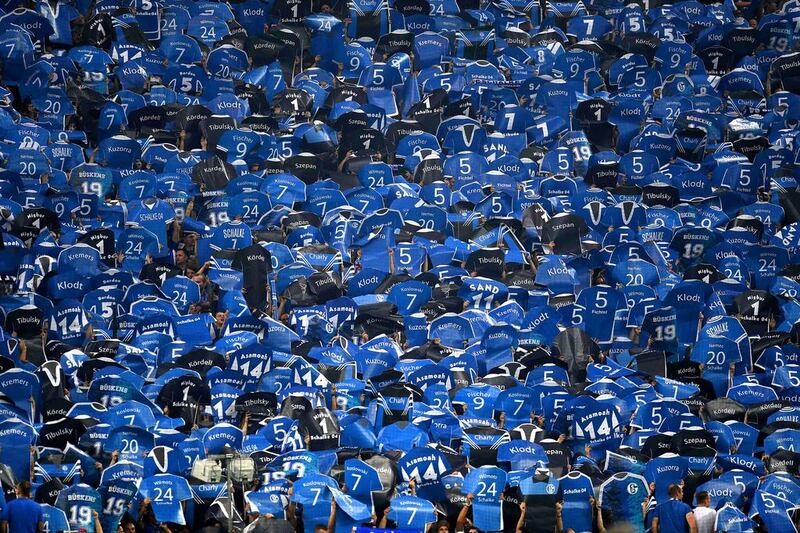 Schalke supporters show paper cut-outs of their players shirts during the German first division Bundesliga football match between Schalke 04 and Bayern Munich in Gelsenkirchen, western Germany. Patrik Stollarz / AFP