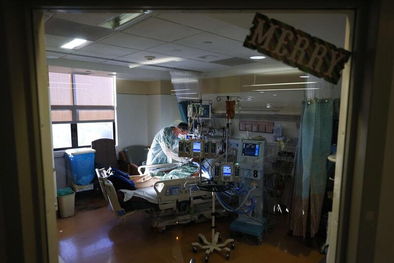 CHULA VISTA, CALIFORNIA - DECEMBER 21: Respiratory therapist Andrew Hoyt cares for a COVID-19 patient in the Intensive Care Unit (ICU) at Sharp Chula Vista Medical Center, with the word 'Merry' posted on the window a few days before Christmas, on December 21, 2020 in Chula Vista, California. According to state figures, Southern California currently has 0 percent of its ICU (Intensive Care Unit) bed capacity remaining amid a spike in COVID-19 cases and hospitalizations.   Mario Tama/Getty Images/AFP
== FOR NEWSPAPERS, INTERNET, TELCOS & TELEVISION USE ONLY ==
