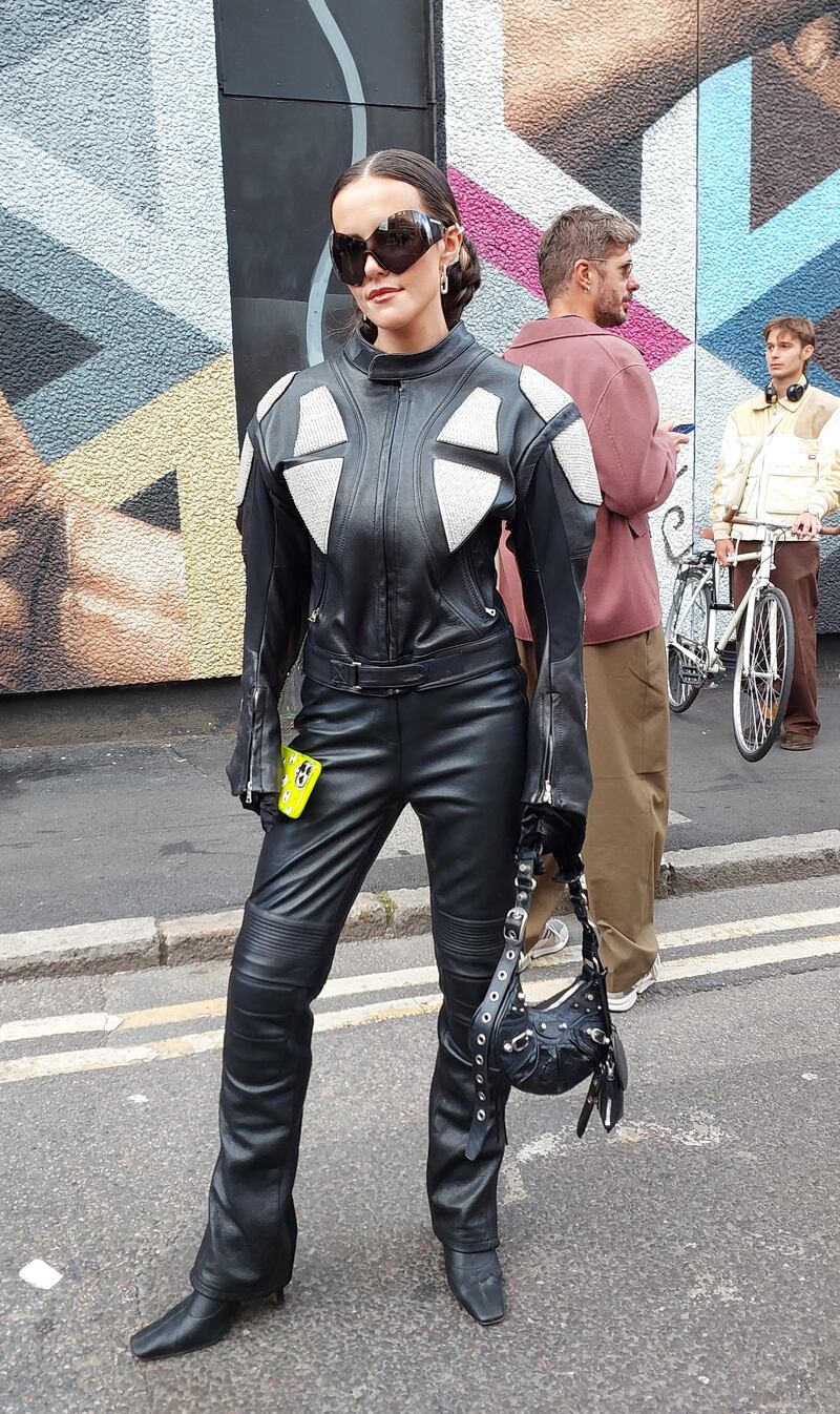 A woman wearing head-to-toe, studded leather. 