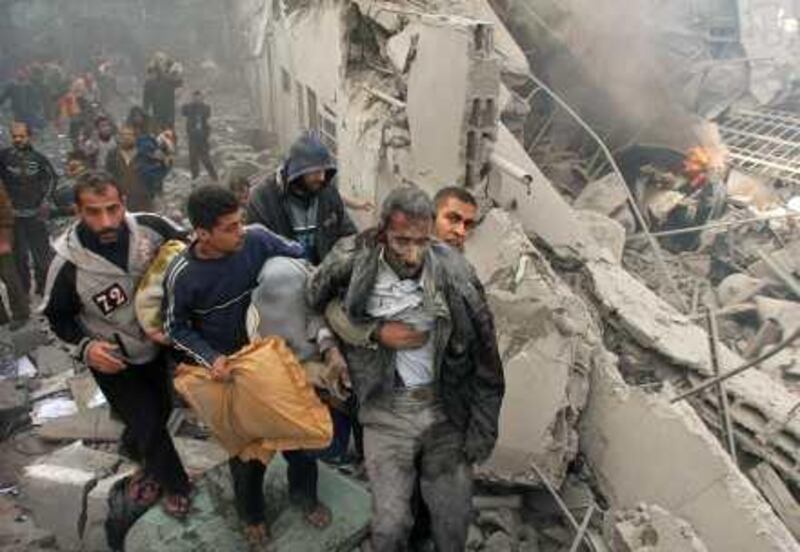 An injured Palestinian prisoner is helped as he and others flee through the rubble of the central security headquarters and prison, known as the Saraya, after it was hit in an Israeli missile strike in in Gaza City, Sunday, Dec. 28, 2008. More than 270 Palestinians have been killed and more than 600 people wounded since Israel's campaign to quash rocket barrages from Gaza began midday Saturday.(AP Photo/Adel Hana) *** Local Caption ***  JRL149_APTOPIX_MIDEAST_ISRAEL_PALESTINIANS_GAZA.jpg