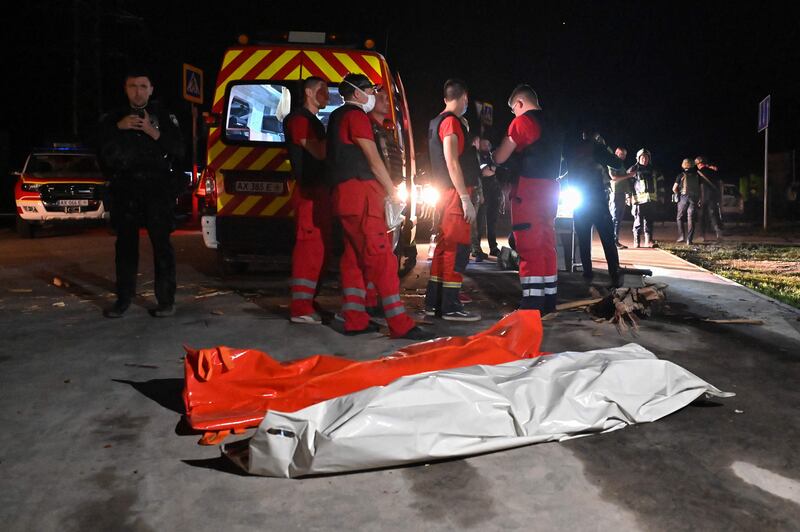 Rescue officials gather in front of the bodies of victims killed in a Russian missile strike on Kharkiv. AFP