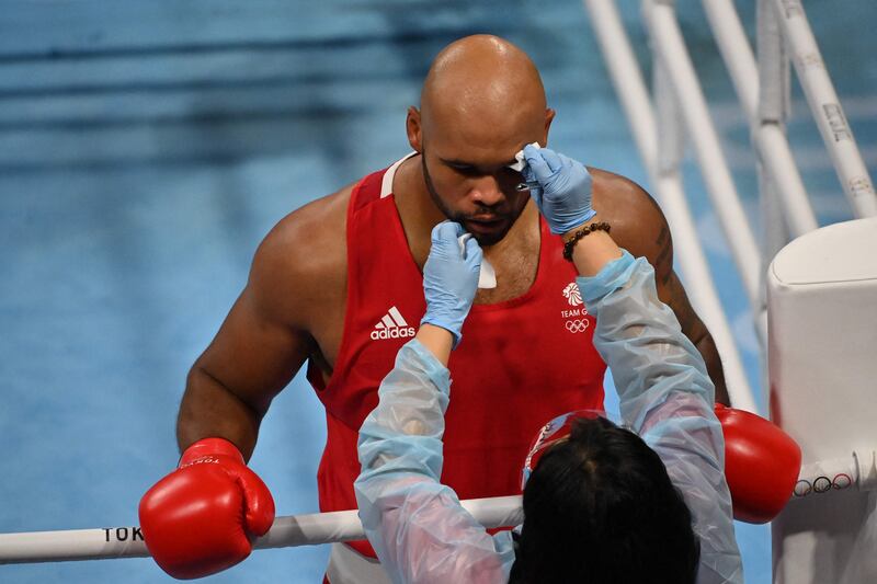 Britain's Frazer Clarke has his cuts attended to after a clash of heads with France's Mourad Aliev.