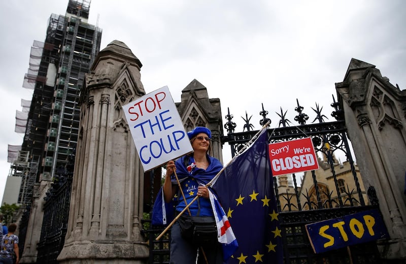 A protestor holds signs during an anti-Brexit protest in Westminster in London, Britain, August 31, 2019. REUTERS/Henry Nicholls