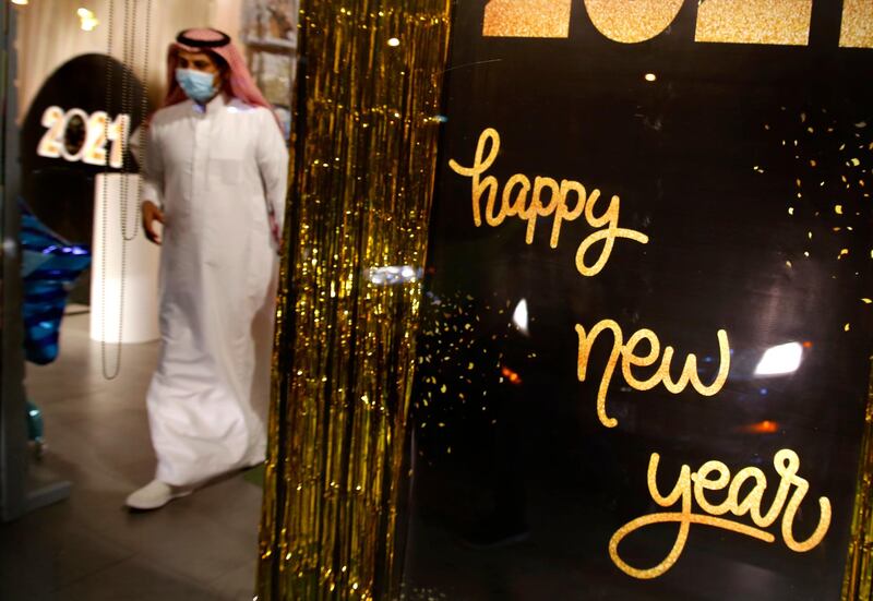 A man wearing a mask to protect from the coronavirus leaves a gift shop decorated for the New Year in Jeddah, Saudi Arabia.  AP