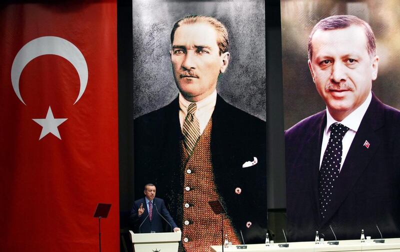 Turkey's president Recep Tayyip Erdogan addresses members of his ruling AK Party, as he stands in front of portraits of himself (R) and Mustafa Kemal Ataturk, the founder of modern Turkey. Adem Altan / AFP 