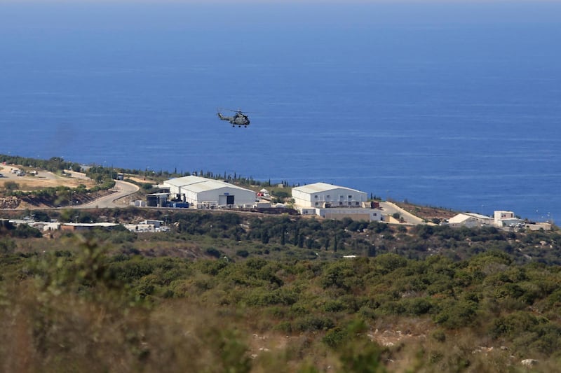 FILE - In this Oct. 14, 2020 file photo, a helicopter flies over a base of the U.N. peacekeeping force, in the southern town of Naqoura, Lebanon. On Wednesday, Oct. 28, 2020, Lebanon and Israel held a second round of U.S.-mediated talks over their disputed maritime border and agreed on a third meeting. The U.S.-mediated talks are being held in a tent at the U.N. post along the border known as Ras Naqoura, on the edge of the Lebanese border town of Naqoura. (AP Photo/Bilal Hussein, File)