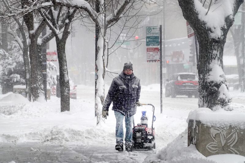 A worker clears snow from the front of a business in Chicago, Illinois. AFP