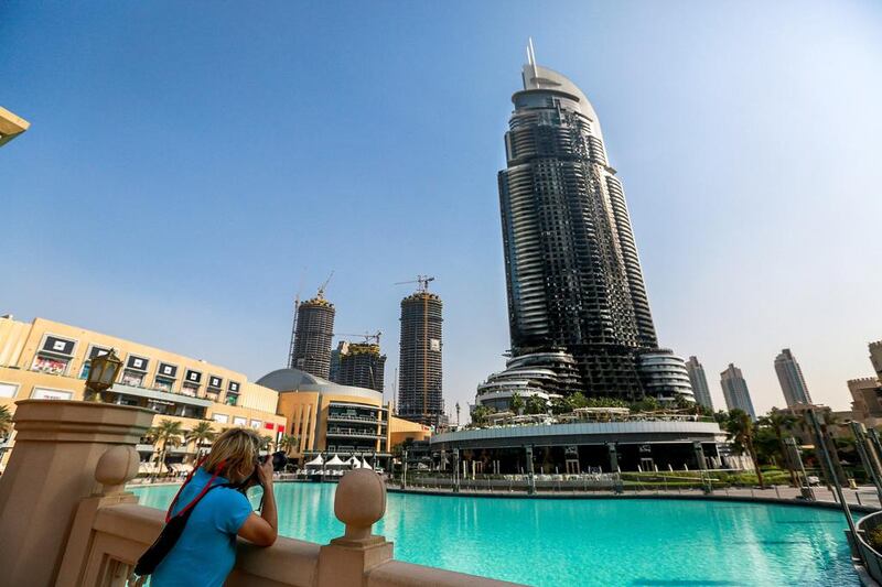 A tourist takes a photo of the burned Address Downtown Dubai hotel.  Victor Besa for The National.