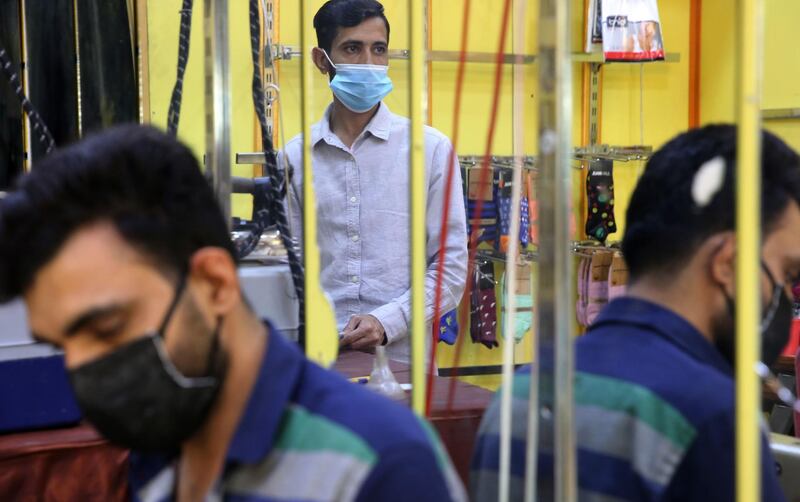 Pakistani and Bengali workers clad in face masks work as tailors at a small factory in Karrada, in the central area of the Iraqi capital Baghdad. AFP