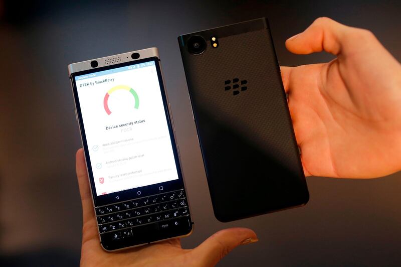 Hosts hold Blackberry KEYone mobilephones at the Mobile World Congress (MWC), the world's biggest mobile fair, on February 26, 2018 in Barcelona.
The Mobile World Congress is held in Barcelona from February 26 to March 1. / AFP PHOTO / Pau Barrena