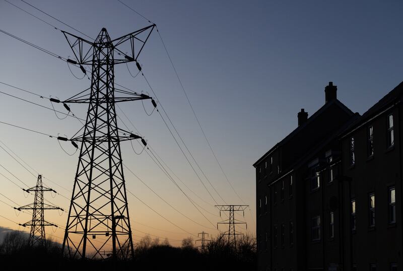 Electricity transmission pylons next to a block of flats in St Neots, England. Bloomberg