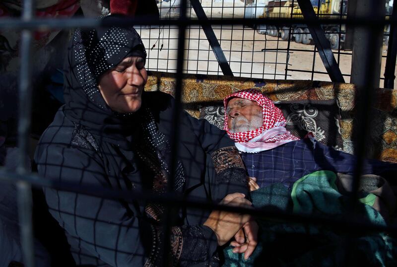 Sumaya Ramadan, left, sits next to her paralysed 92-year-old uncle Abdul-Moati Abu-Zeid, right, who laid on a mattress not moving or speaking, in a pickup truck getting ready to cross into Syria from the eastern Lebanese border town of Arsal, Lebanon, on June 28, 2018. Bilal Hussein / AP Photo