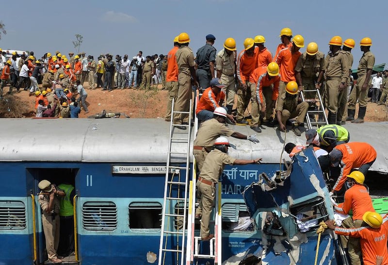 Indian fire and rescue crews try to prize open a carriage of the Bangalore-Ernakulam train which derailed after a boulder fell on the track in Bidaragere. Manjunath Kiran / AFP Photo