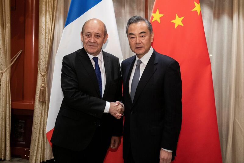 China's Foreign Minister Wang Yi shakes hands with his French counterpart Jean-Yves Le Drian at Diaoyutai State Guesthouse in Beijing, China.  Reuters