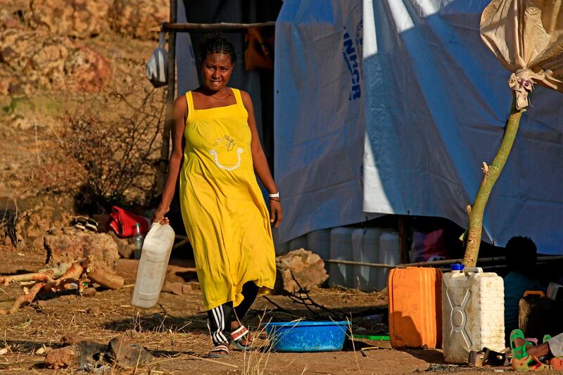 An Ethiopian woman who fled fighting in Tigray province walks with a water container at the Um Rakuba camp in Sudan's eastern Gedaref province.  AFP