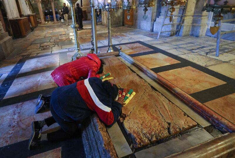 Worshippers pray at the Stone of Anointing – the place where Jesus Christ's body is believed to rest. AFP