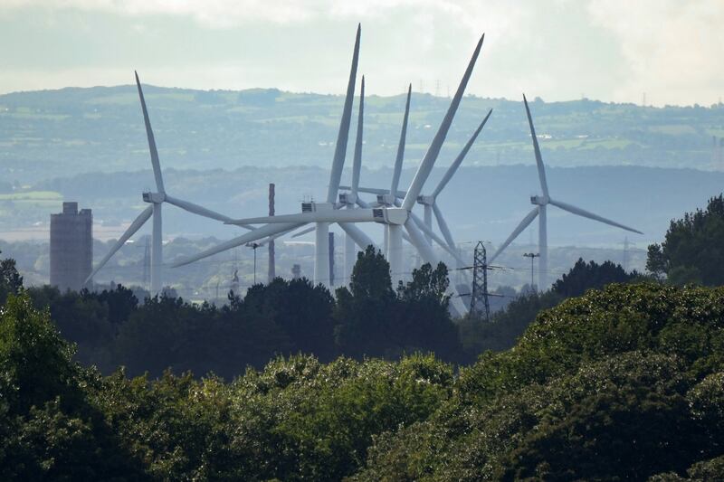 Wind turbines and electricity pylons dominate the landscape at Ince Salt Marshes near to chemical and manufacturing plants on the River Mersey estuary in Runcorn, England. Getty Images