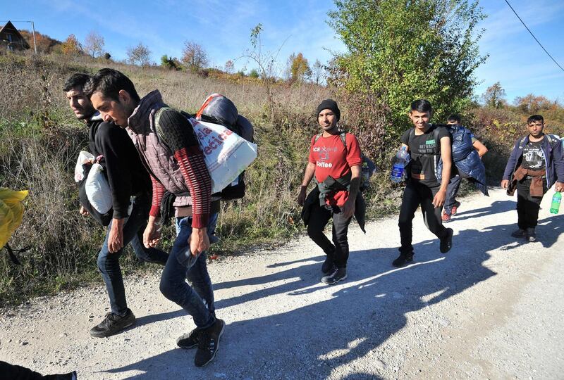 A group of Asian migrants are seen while marching on a dirt road, while attempting to illegaly cross into Croatia via Pljesevica mountain, near Northern-Bosnian town of Bihac, on October 25, 2018. In their struggle with large number of in coming migrants, Bosnian authorities have provided two additional capacities, in abandoned army barracks in Hadzici and a former appliance factory in Bihac. Regardless of the authority's efforts, groups of migrants chose to leave Bosnia and attempt an illegal crossing into neighboring Croatia, hoping to travel further into the EU countries.   / AFP / ELVIS BARUKCIC
