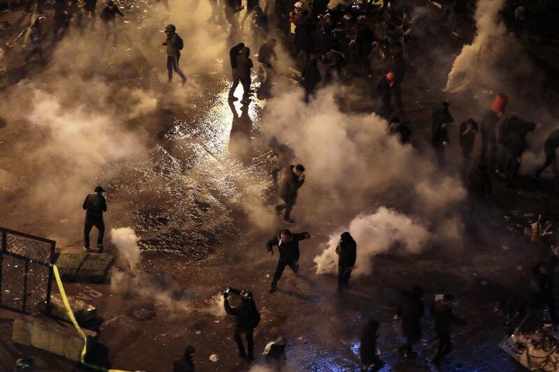 Lebanese anti-government protesters run to avoid tear gas as security forces attempt to disperse their rally near the Grand Serail in downtown Beirut. AFP