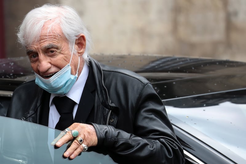 Jean-Paul Belmondo wears a face mask while waving to the public as he leaves the funeral ceremony for French screenwriter Guy Bedos, in Paris in June 2020. EPA