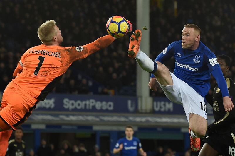 Leicester City's Danish goalkeeper Kasper Schmeichel comes out to punch the ball as Everton striker Wayne Rooney jumps during the Premier League match at Goodison Park in Liverpool on January 31, 2018. AFP