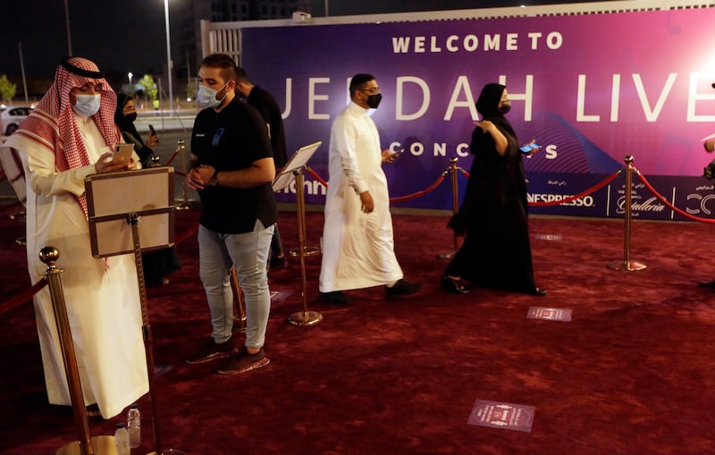 Concert-goers show their coronavirus vaccine certificates as they enter the arena.