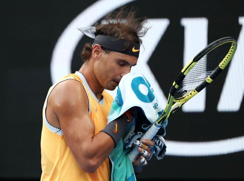 Rafael Nadal wipes his face with a towel during the match. Reuters