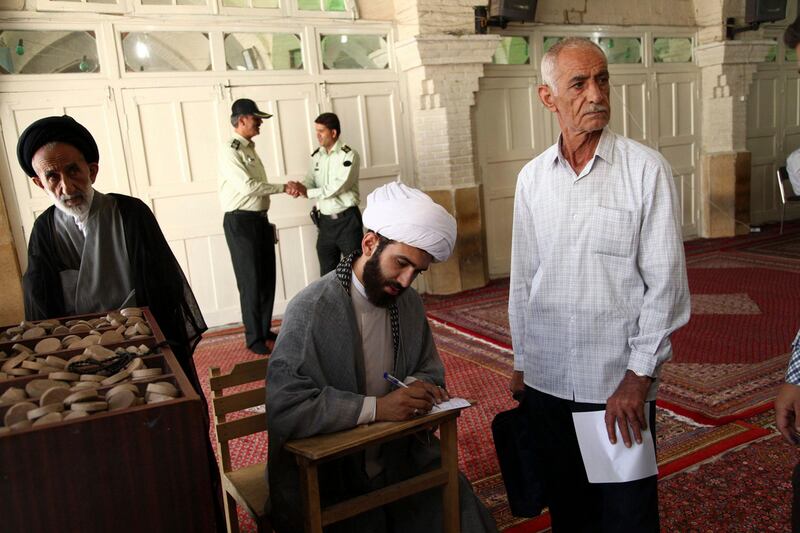 A cleric fills in his ballot paper during the Iranian presidential election at a mosque in Qom, 120 km (74.6 miles) south of Tehran June 14, 2013. Iranians voted for a new president on Friday urged by Supreme Leader Ayatollah Ali Khamenei to turn out in force to discredit suggestions by arch foe the United States that the election would be unfair. REUTERS/Fars News/Mohammad Akhlagi  (IRAN - Tags: POLITICS ELECTIONS) ATTENTION EDITORS - THIS IMAGE WAS PROVIDED BY A THIRD PARTY. FOR EDITORIAL USE ONLY. NOT FOR SALE FOR MARKETING OR ADVERTISING CAMPAIGNS. THIS PICTURE IS DISTRIBUTED EXACTLY AS RECEIVED BY REUTERS, AS A SERVICE TO CLIENTS *** Local Caption ***  CJF10_IRAN-ELECTION_0614_11.JPG