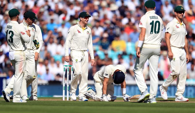 Joe Denly down on his knees after being struck by a painful blow at The Oval. PA