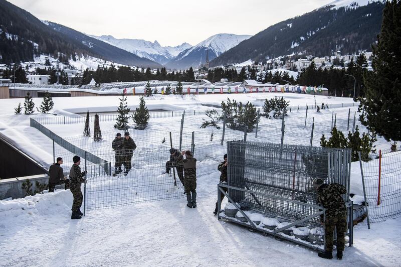 Soldiers of the Swiss Army set up fences around the congress centre.  EPA
