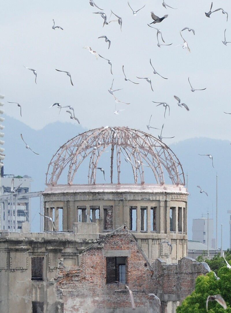 Doves fly around the Atomic Bomb Dome at the Peace Memorial Park after being released during the memorial service to remember the 1945 atomic bombing of Hiroshima on August 6, 2011. Japan marks the 66th anniversary of US atomic bombing of Hiroshima as the country struggles to end a crisis at a nuclear power plant ravaged by the March quake-tsunami disaster.  AFP PHOTO / TORU YAMANAKA
 *** Local Caption ***  560281-01-08.jpg