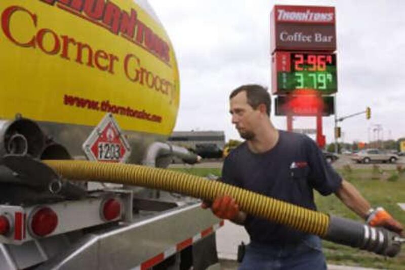 Gas truck delivery driver Tim Trabue packs away gas lines after unloading gas into underground holding tanks at a gas station in Springfield, Ill., US, on Oct 15 2008. Oil prices dipped below $70 a barrel, a new 15-month low.