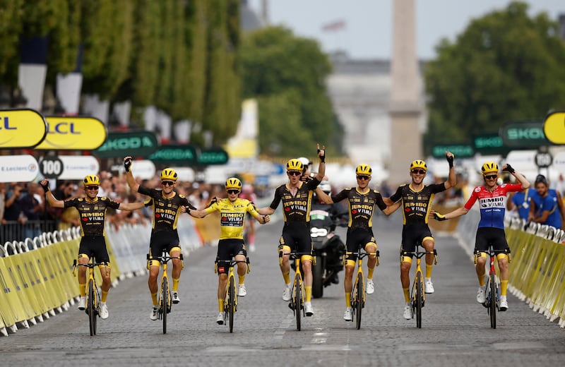 Jumbo–Visma's Jonas Vingegaard, in yellow, crosses the finish line with his teammates after Stage 21. Reuters