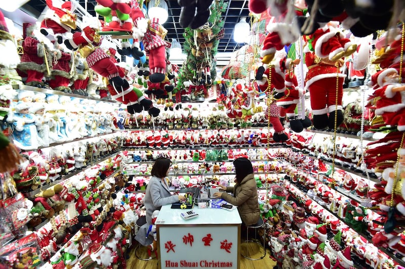 Women sit in a store selling Christmas products at the Yiwu Wholesale Market in Yiwu, Zhejiang province, China. Reuters
