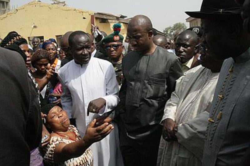 A Nigerian woman tells Goodluck Jonathan, the president, right, of her acocunt of the Christmas Day bombings on a church in Madalla near the capital Abuja.